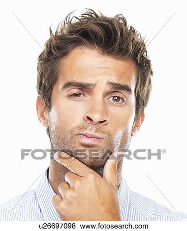 Stock Photo - Close-up portrait of confused business man with had on chin against white background. Fotosearch