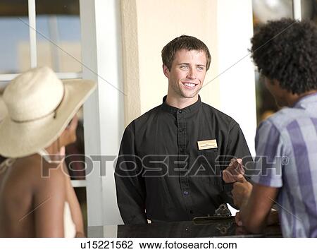 Stock Image - Couple checking in to hotel. Fotosearch