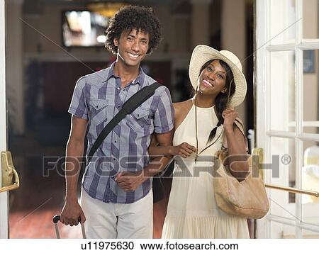 Couple exiting hotel with their luggage View Large Photo Image Stock Image - Couple exiting hotel with their luggage . Fotosearch