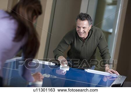 Couple playing air hockey View Large Photo Image Stock Image - Couple playing air hockey. Fotosearch