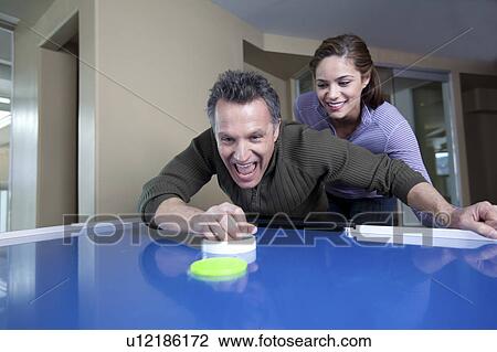 Couple playing air hockey View Large Photo Image Stock Image - Couple playing air hockey. Fotosearch