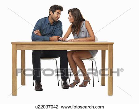 Stock Image - Couple sitting at table and discussing financial matter. Fotosearch
