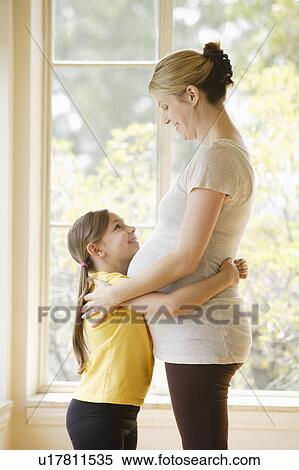 Daughter (6-7) embracing pregnant mother View Large Photo Image Stock Photography - Daughter (6-7) embracing pregnant mother. Fotosearch