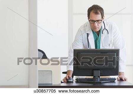 Doctor using computer View Large Photo Image Stock Photography - Doctor using computer. Fotosearch
