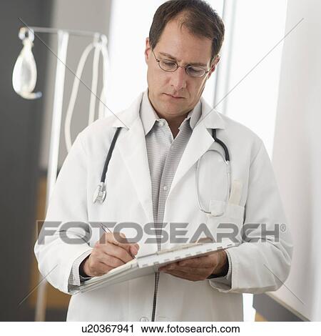 Stock Image - Doctor writing in clipboard. Fotosearch