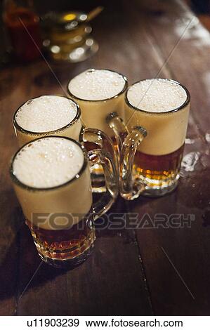 Four beers on bar View Large Photo Image Stock Photo - Four beers on bar. Fotosearch