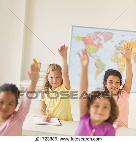 Stock Photograph - Four girls (6-9) raising hands in classroom. Fotosearch