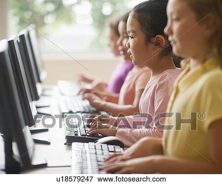 Stock Photo - Four girls (6-9) using computers. Fotosearch