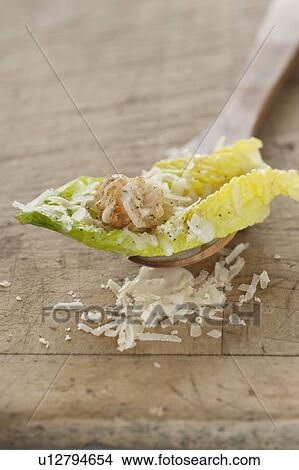Picture - Fresh caesar salad on wooden spoon. Fotosearch