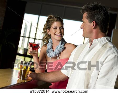Friends enjoying drinks at bar View Large Photo Image Picture - Friends enjoying drinks at bar. Fotosearch