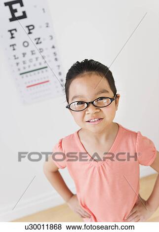 Stock Photo - Girl (6-7) at eye exam. Fotosearch