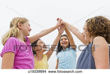 Picture - Girls (6-9) holding arms up in sky. Fotosearch