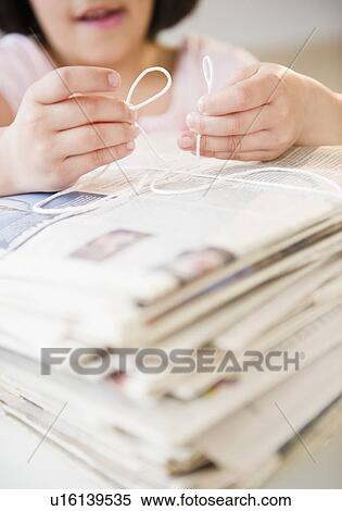 Girl's (8-9) hands tying pile of newspapers with string View Large Photo Image Stock Photography - Girl's (8-9) hands tying pile of newspapers with string. Fotosearch