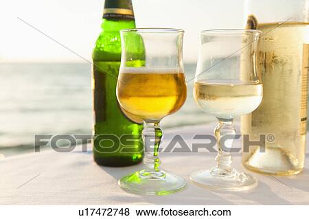 Greece, Cyclades Islands, Mykonos, Beer and wine on table by sea View Large Photo Image Stock Photo - Greece, Cyclades Islands, Mykonos, Beer and wine on table by sea. Fotosearch