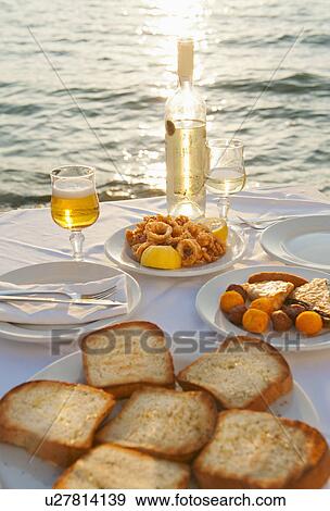 Greece, Cyclades Islands, Mykonos, Calamari appetizer on set table by sea View Large Photo Image Stock Photo - Greece, Cyclades Islands, Mykonos, Calamari appetizer on set table by sea. Fotosearch