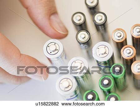 Stock Image - Hand holding batteries. Fotosearch