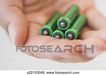Stock Photo - Hand holding batteries. Fotosearch
