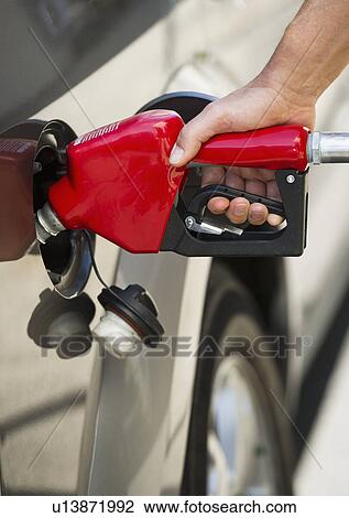 Hand holding fuel pump refueling car View Large Photo Image Stock Image - Hand holding fuel pump refueling car. Fotosearch