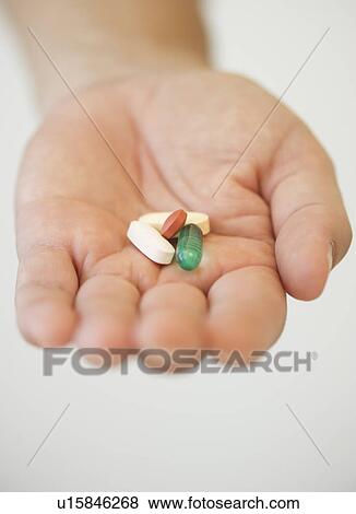Stock Photo - Hand holding pills. Fotosearch