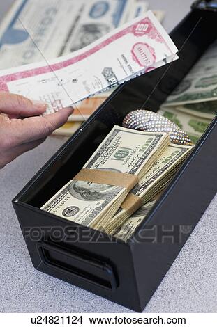 Hand inserting valuables into safe deposit box View Large Photo Image Picture - Hand inserting valuables into safe deposit box. Fotosearch