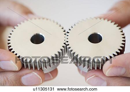 Stock Image - Hands holding gears. Fotosearch