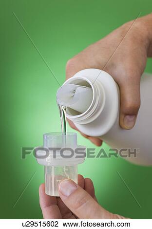 Stock Image - Hands pouring cleaning liquid. Fotosearch