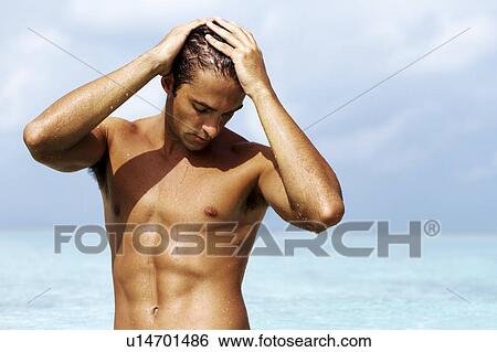 Handsome young guy standing in the sea View Large Photo Image Stock Photograph - Handsome young guy standing in the sea. Fotosearch