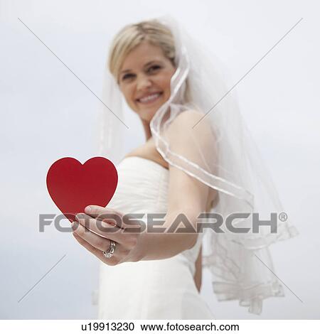 Happy bride holding red heart View Large Photo Image Stock Image - Happy bride holding red heart. Fotosearch