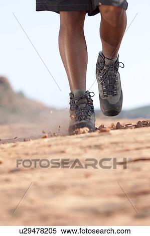 Stock Photography - Hiking boots moving across rocky surface. Fotosearch