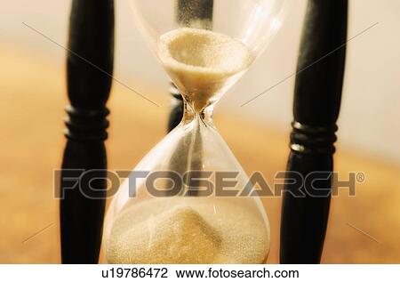 Stock Image - Hourglass with pouring sand. Fotosearch