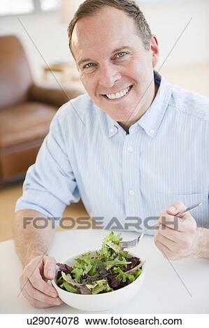 Man eating salad View Large Photo Image Stock Photo - Man eating salad. Fotosearch