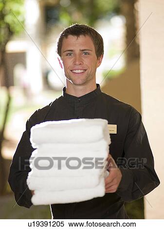 Man from room service delivering towels to hotel guest View Large Photo Image Stock Photography - Man from room service delivering towels to hotel guest. Fotosearch