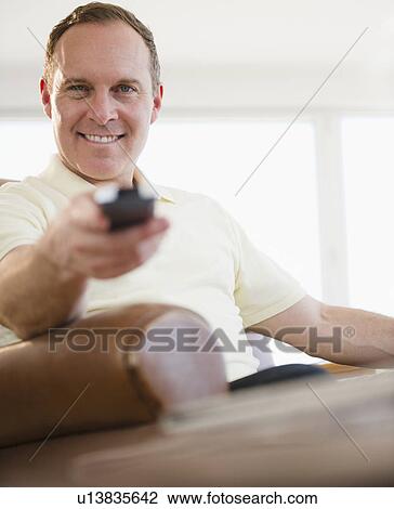 Man holding remote control View Large Photo Image Stock Image - Man holding remote control. Fotosearch