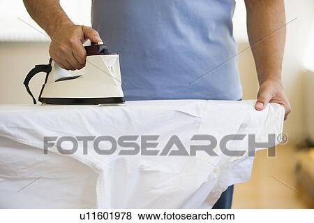 Stock Photo - Man ironing shirt. Fotosearch