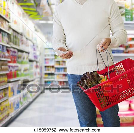 Man shopping, holding list and basket View Large Photo Image Stock Image - Man shopping, holding list and basket. Fotosearch