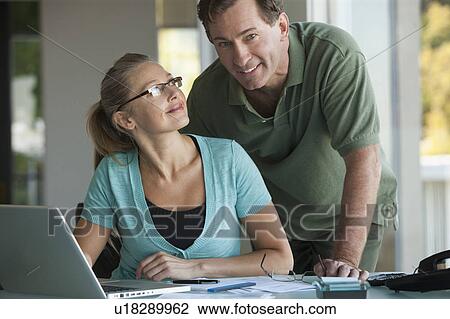 Mature couple working on laptop at home View Large Photo Image Stock Image - Mature couple working on laptop at home. Fotosearch