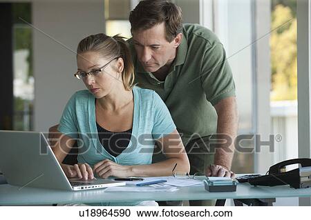 Mature couple working on laptop at home View Large Photo Image Stock Image - Mature couple working on laptop at home. Fotosearch