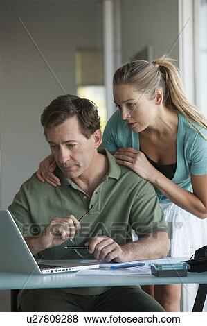 Mature couple working on laptop at home View Large Photo Image Stock Photo - Mature couple working on laptop at home. Fotosearch