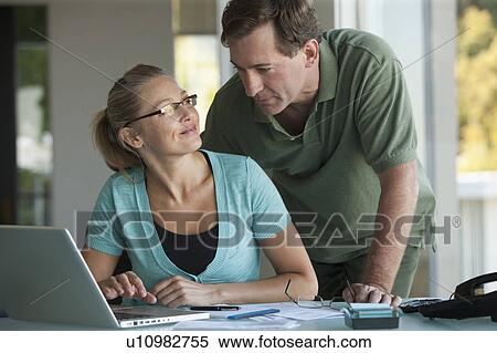 Stock Photography - Mature couple working on laptop at home. Fotosearch