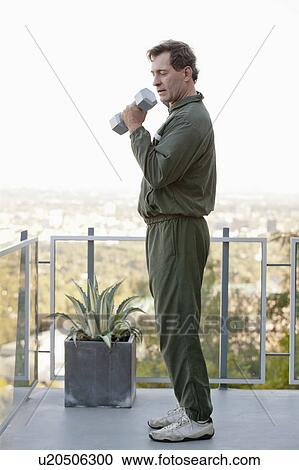 Mature man exercising on balcony View Large Photo Image Stock Image - Mature man exercising on balcony. Fotosearch