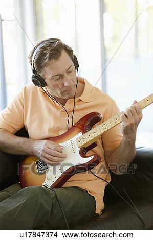 Picture - Mature man playing guitar. Fotosearch