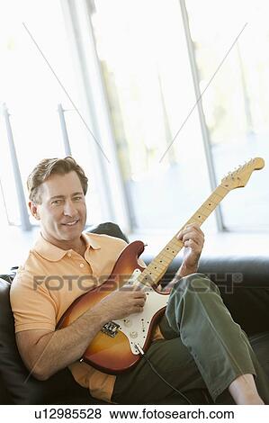 Stock Photo - Mature man playing guitar. Fotosearch