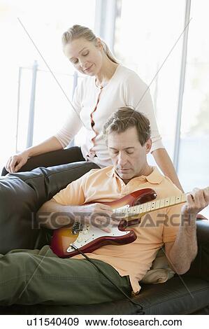Mature man playing guitar while woman listening View Large Photo Image Stock Photo - Mature man playing guitar while woman listening. Fotosearch