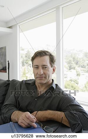 Stock Photo - Mature man relaxing on sofa. Fotosearch