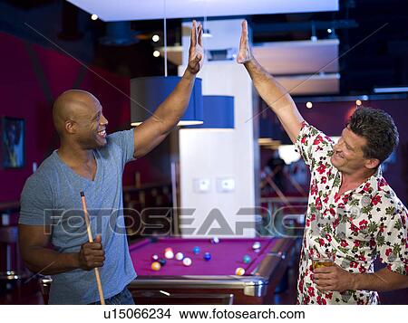 Picture - Men enjoying game of pool at bar. Fotosearch