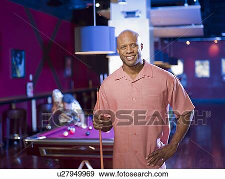 Stock Photo - Men enjoying game of pool at bar. Fotosearch
