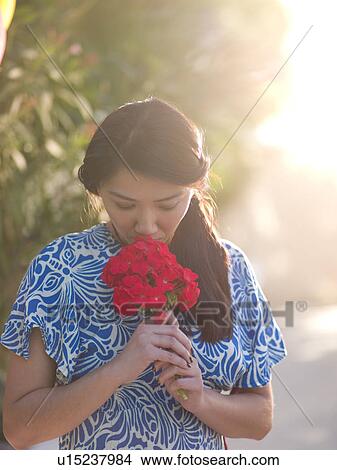 Picture - Mid adult woman smelling bouquet. Fotosearch