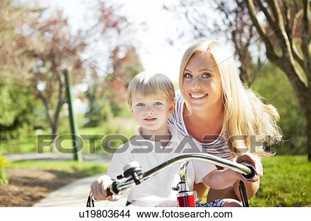 Mother and son (2-3) riding tricycle in park View Large Photo Image Picture - Mother and son (2-3) riding tricycle in park. Fotosearch