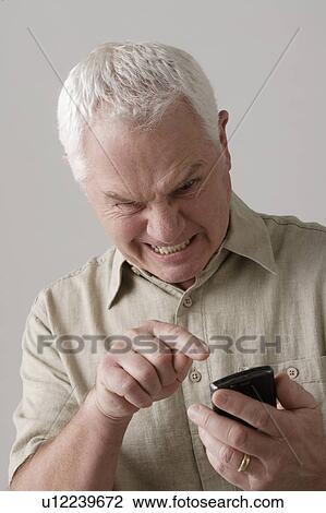 Portrait of angry senior man with mobile phone, studio shot View Large Photo Image Stock Image - Portrait of angry senior man with mobile phone, studio shot. Fotosearch