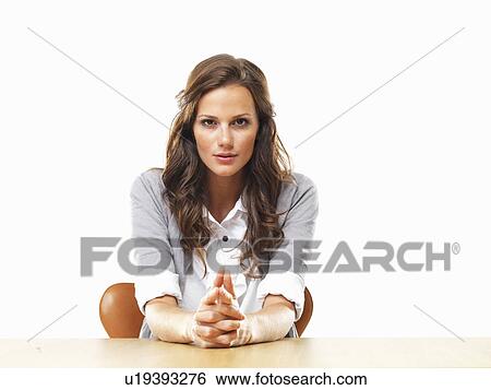 Portrait of attractive business woman sitting at table with hands clasped View Large Photo Image Stock Photograph - Portrait of attractive business woman sitting at table with hands clasped. Fotosearch